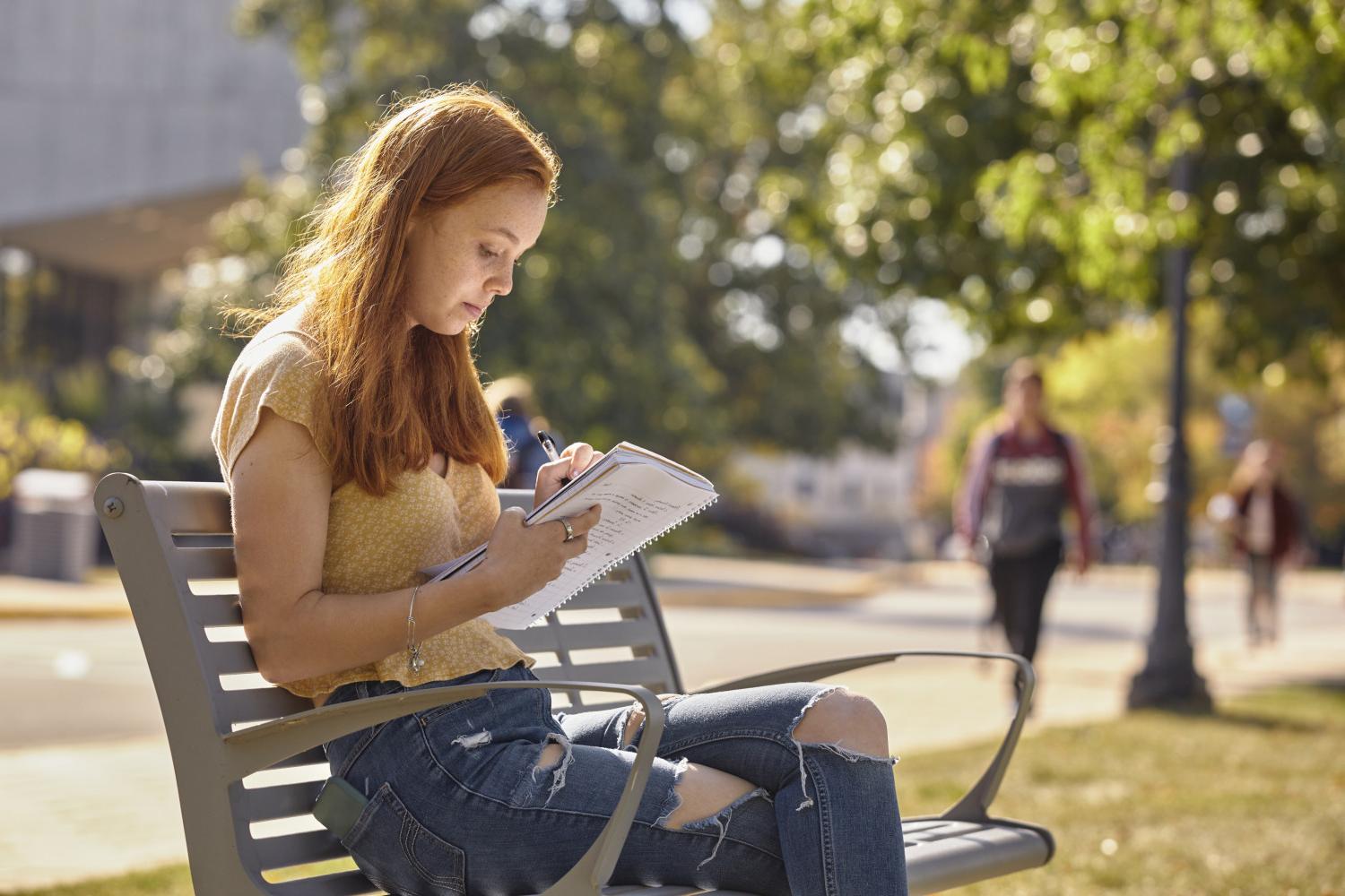 一位<a href='http://i7s.sh-fyz.com'>全球十大赌钱排行app</a>学院的学生在校园里的长椅上读书.